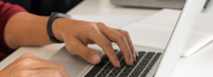 close up of hands typing on a keyboard