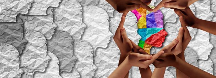 Hands around a multi coloured head silhouette representing Autism