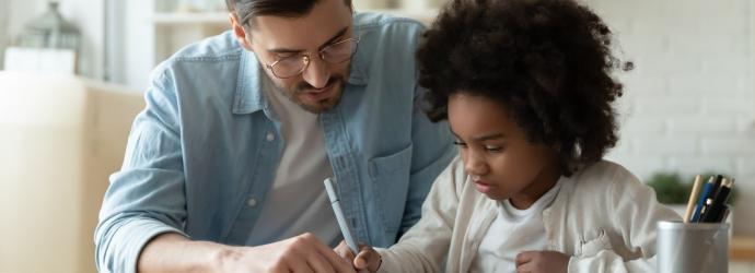 parent home schooling a child at a kitchen table