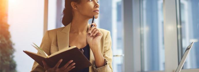 woman sitting a desk thinking pensively