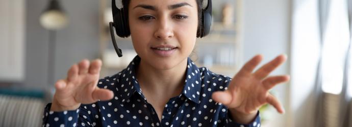 woman talking to a laptop wearing a headset