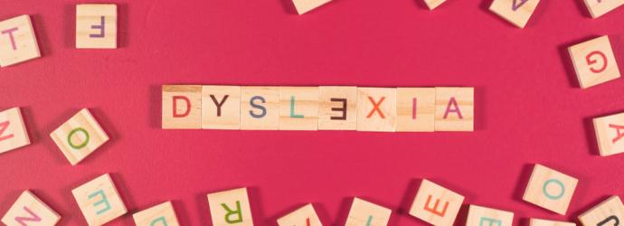 Colourful letter blocks spelling out "Dyslexia" with other lettered blocks around it.