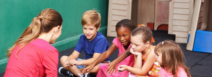 Group of EY Children reading a book with their education practitioner