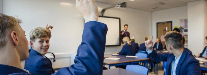 Male teacher in a secondary classroom teaching