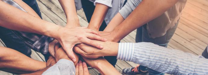 Group of people with their hands out in the middle of a circle