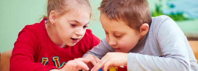 Two children with SEND playing a board game in school