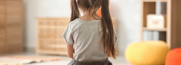 child sitting alone with her back towards to the camera