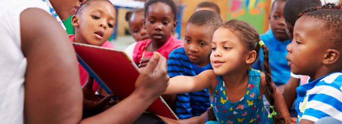 Group of Early Years children reading a book