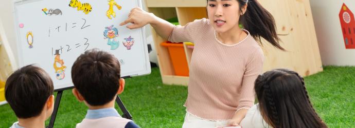 Early Years practitioner with a group of 3 early years children in a Early Years setting learning maths