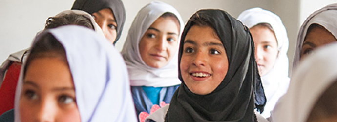A group of children wearing hijabs in a classroom