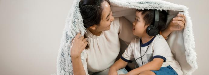 woman_and_young_boy_smiling_under_blanket