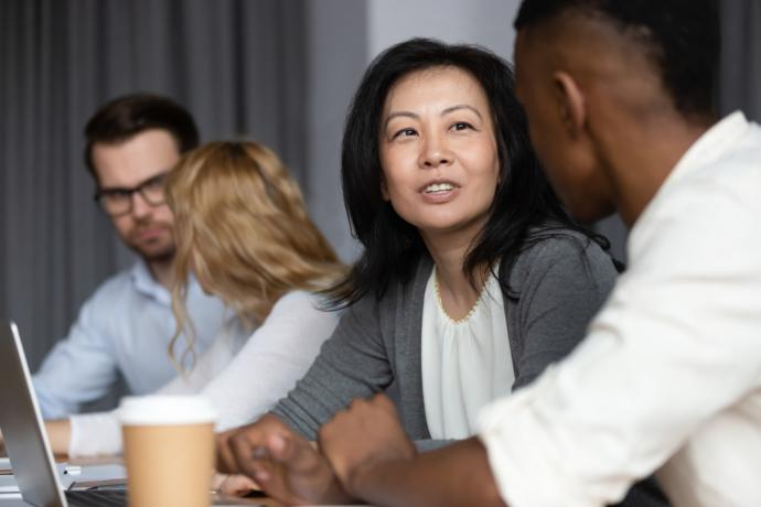 4 adult professionals talking around a table