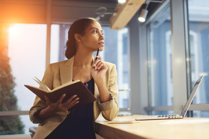 woman sitting a desk thinking pensively