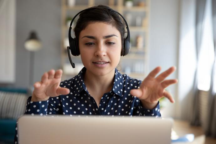 woman talking to a laptop wearing a headset