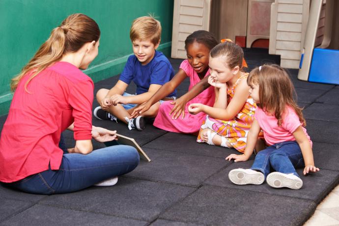 Group of EY Children reading a book with their education practitioner