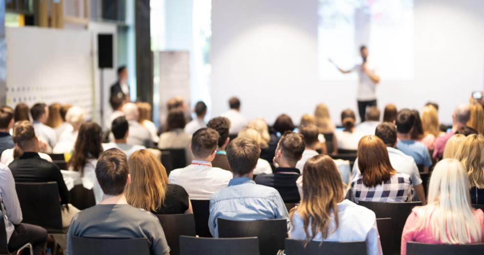 Male delivering a training session in front of an audience